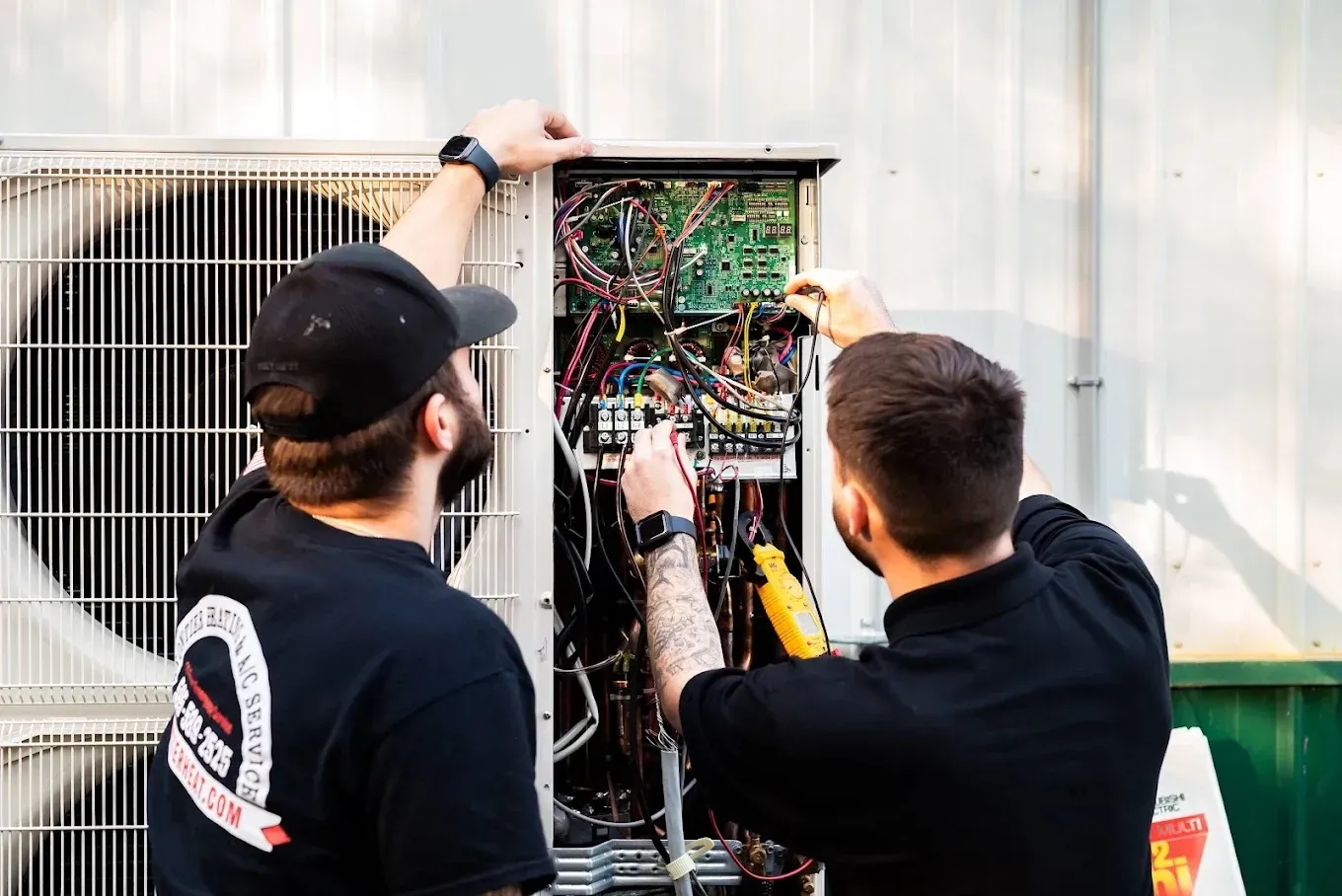 Get Ready for Summer: Spring AC Tune-Up Checklist 2 HVAC technician inspecting an air conditioning unit outdoors